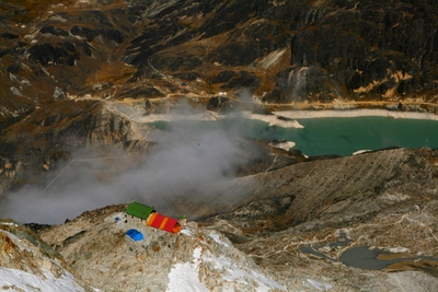 huayna potosi, picture 4: high camp in the lower left for people that don't have to climb as far as us the first day (base camp visible on the far side of the lake). click on the image to go to the next picture